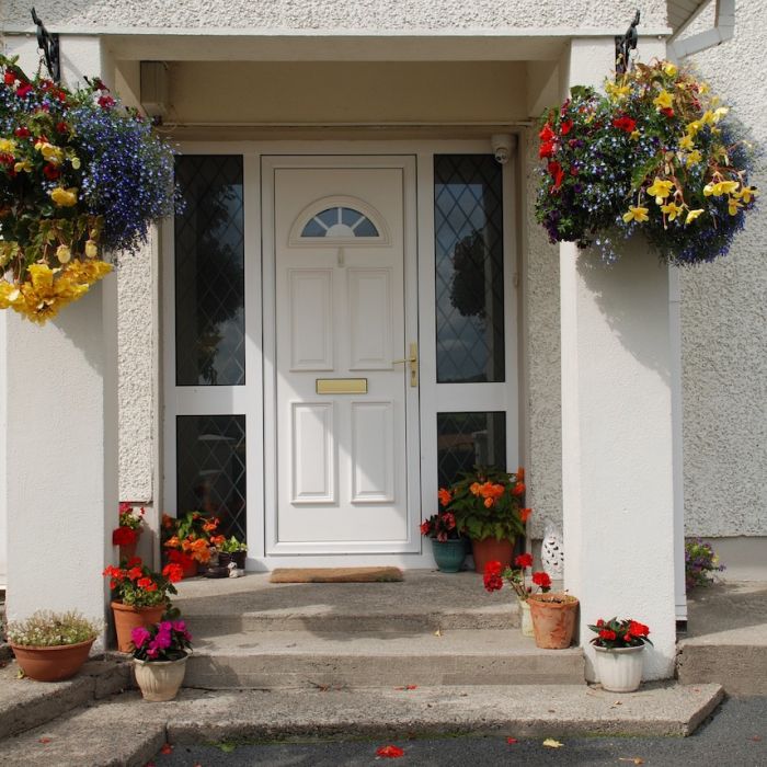white exterior door with flowers on the porch
